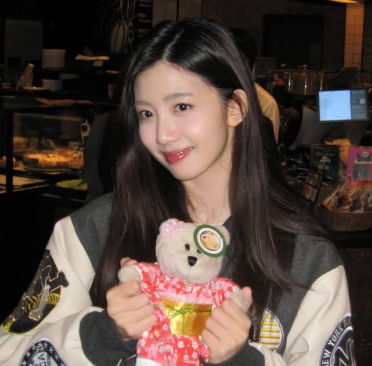 Choi Yu-ju segurando um ursinho de pelúcia