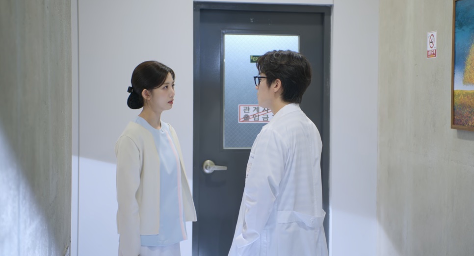 O An Gi-jun conversando com uma mulher no corredor da clínica