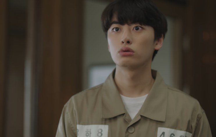 Yang Jeong-il de uniforme de detento, olhando fixamente para a frente no tribunal