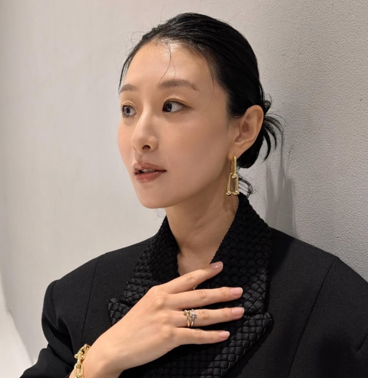 Hyunri de blazer preto durante uma entrevista
