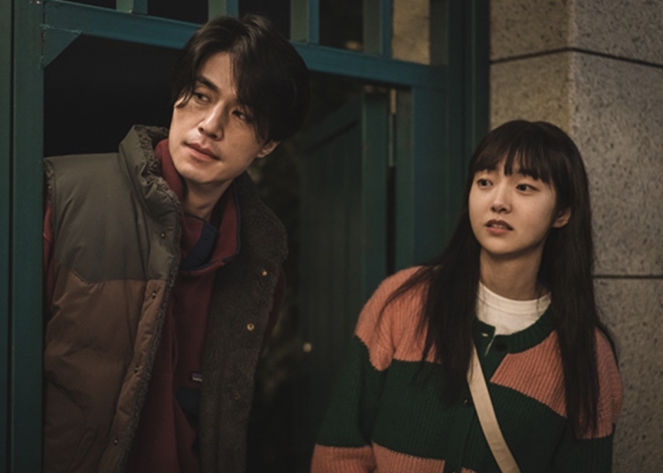 Jeong Jin-man de colete acolchoado ao lado da sobrinha, Jeong Ji-an, na porta de uma casa