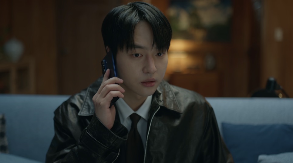 Yang Se-jong hoje, de maxilar marcado e cabelo curto para trás, de jaqueta de couro e gravata, ao telefone