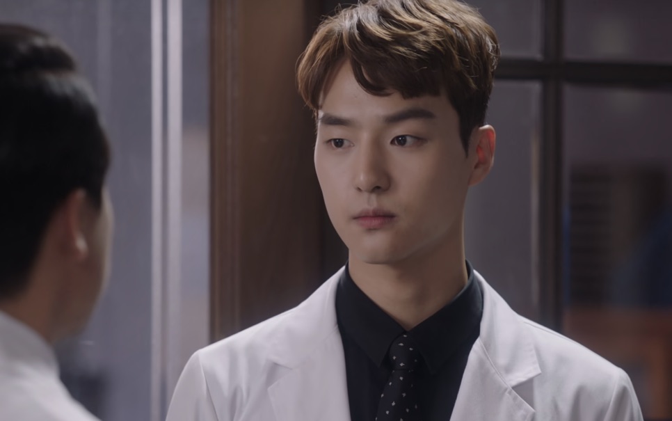 Yang Se-jong em 2016, de rosto fino e cabelo claro, de jaleco branco num hospital