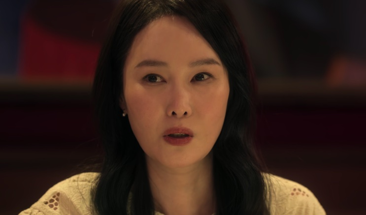 Park Seong-hee de blusa clara, falando em um restaurante