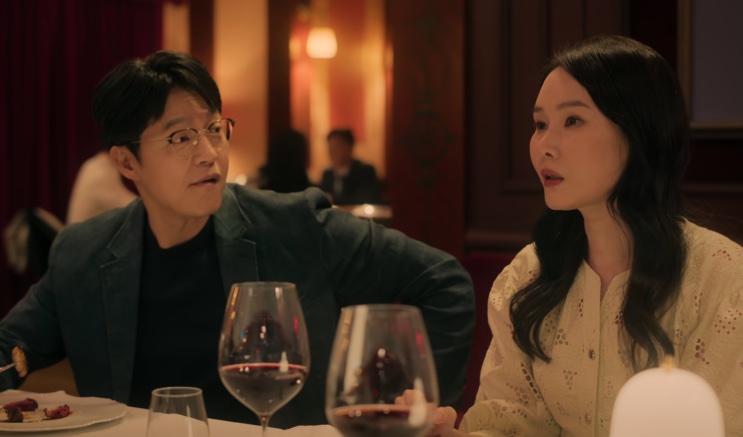 Duas pessoas conversando em uma mesa de restaurante com taças de vinho