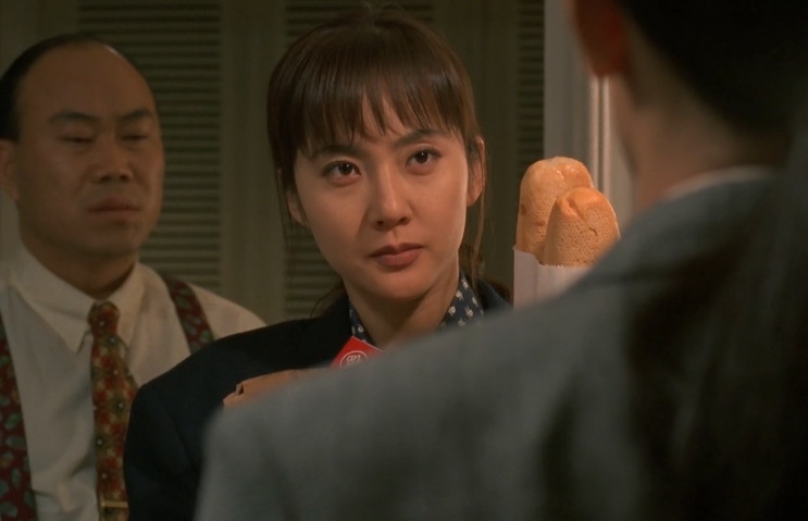Yum Jung-ah numa cena de Terrorista, de blusa clara, olhando para um homem