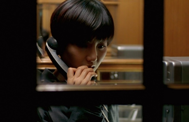 Yum Jung-ah ao telefone numa cena escura do filme